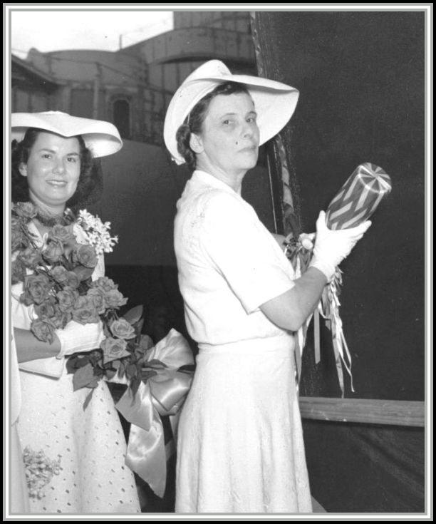 photograph of Mrs. Savage holding champagne bottle before christening