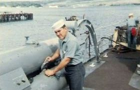 photograph of Ernie performing preventive maintenance on the port torpedo tube rack